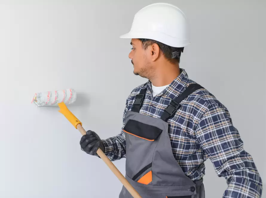Alcora Reformas Madrid - Operario realizando trabajos de pintura con rodillo en una vivienda